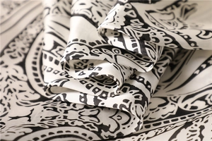 Close-up of silk-like paisley pattern scarf showing intricate black and white ethnic details