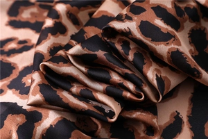 Macro shot of silk leopard print fabric showing smooth texture and glossy finish