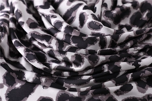 Macro shot of smooth leopard print silk scarf fabric with elegant draped folds