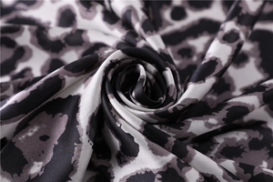 Macro shot of silk leopard print fabric showing smooth texture and glossy finish