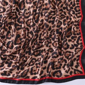 Leopard print silk scarf for women featuring red and black contrast borders and smooth texture