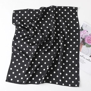 Detail of black and white polka dot satin square scarf with delicate hem and floral decor