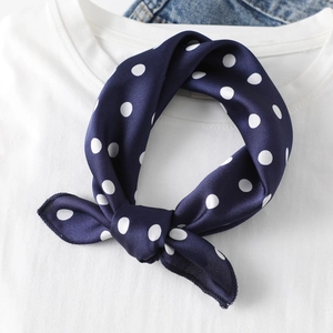 Polka dot navy blue silk scarf tied on a white t-shirt for chic styling accessory
