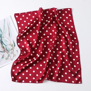 Macro shot of red silk scarf with white polka dots featuring premium hemmed edges