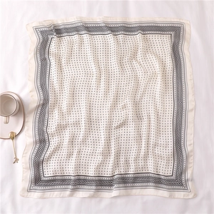 Détail d'un foulard carré en soie 70x70cm avec motifs géométriques noirs et vagues