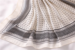 Gros plan d'un foulard en soie à motifs géométriques avec un drapé élégant et texturé