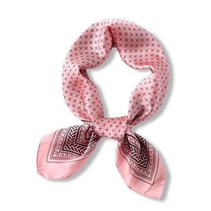 Carré en soie rose avec motif en croix noir et bordure géométrique sur fond blanc
