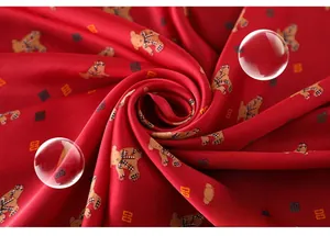 Macro detail of silky red scarf showing cute teddy bear print and smooth fabric texture