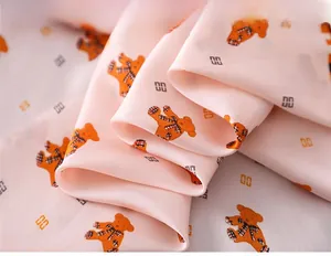 Detail of soft pink silk scarf featuring cute bear prints and smooth satin texture