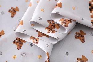Detailed macro view of silky white fabric featuring cute bear print and geometric pattern