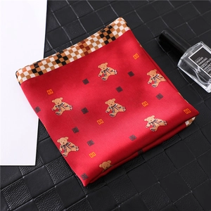 Detail of red silk square scarf with cute teddy bear pattern and plaid border