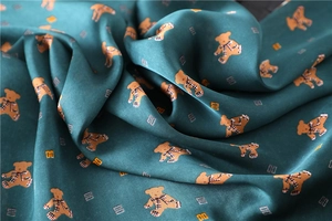 Detail of silk satin square scarf with cute bear pattern and luxury geometric print