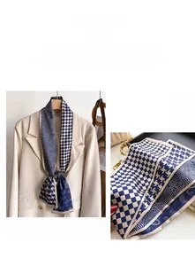 Detailed pattern of geometric checkered silk scarf styled on a beige blazer
