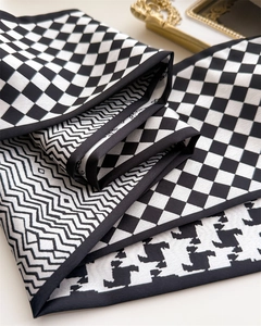 Macro shot of geometric black and white silk scarf with houndstooth and checkered patterns