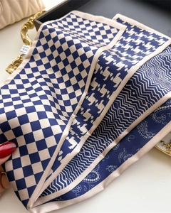 Macro shot showing soft geometric pattern silk scarf texture and detailed edge stitching