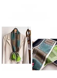 Détail d'un foulard en soie vintage à motif cachemire porté sur un blazer beige chic