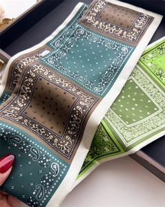 Gros plan du foulard en soie vintage avec motifs paisley en vert et tons caramel