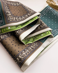 Détail d'un foulard en soie vintage avec motifs paisley et texture lisse satinée