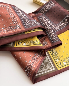Détail rapproché d'un foulard en soie à imprimé paisley rétro avec une texture soyeuse