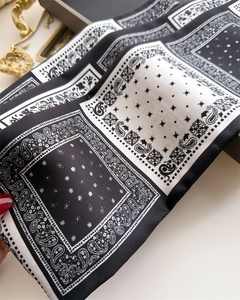Détail d'un foulard en satin noir et blanc avec motifs Paisley et imprimés géométriques