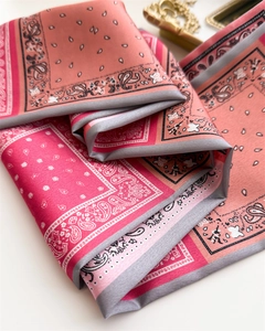 Détail d'un foulard en soie paisley rose montrant la texture douce et le motif floral
