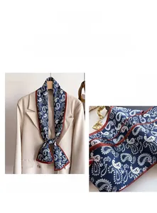 Détail d'un foulard en soie paisley bleu marine avec bordure rouge sur un costume beige