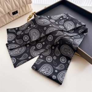 Détail d'un foulard en soie à motif paisley noir et blanc avec une finition satinée