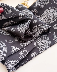 Détail d'un foulard en soie noir à motif cachemire avec texture satinée douce
