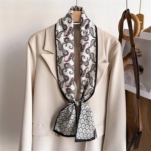 Elegant paisley print silk scarf in off-white tied on a cream suit collar decoration