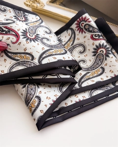 Gros plan d'une écharpe en soie à motif paisley avec bordure en satin noir