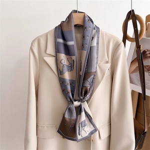 Equestrian print silk scarf with horse and saddle patterns on a beige suit blazer