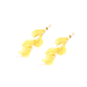 Detailed view of yellow chiffon tassel earrings with pearls and golden chains