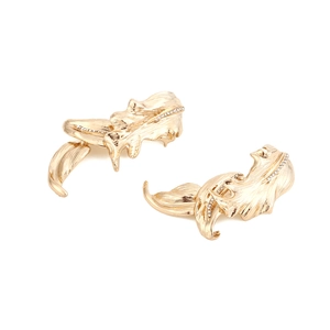 Macro detail of golden leaf earrings with brushed metal texture and sparkling crystals