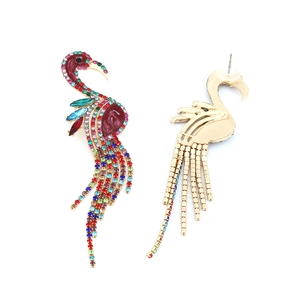 Detailed view of colorful rhinestone flamingo earrings with long tassels and gold finish