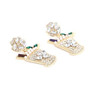 Macro view of gold-tone geometric wine glass earrings with white rhinestones and pearls