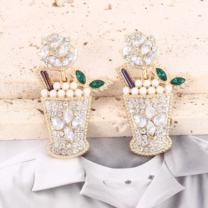 Macro shot of gold-plated cocktail glass earrings with crystal pavé and pearl foam detail
