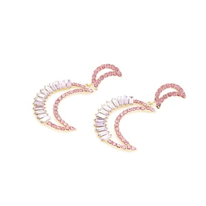 Exaggerated golden moon earrings with pink rhinestones and crescent crystal design
