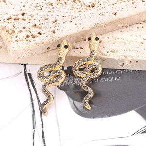 Boucles d'oreilles serpent dorées à la mode avec strass foncés sur une plaque en pierre