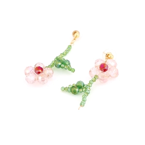 Detail of handmade beaded flower earrings featuring pink glass petals and golden studs