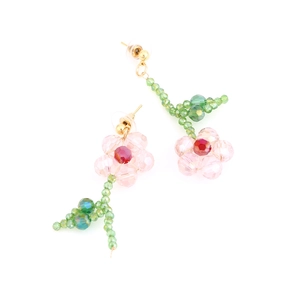 Detail of handmade beaded flower earrings featuring pink crystal petals and green stems
