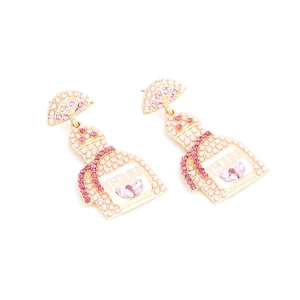 Detailed macro view of gold-plated tequila bottle earrings with pink rhinestones
