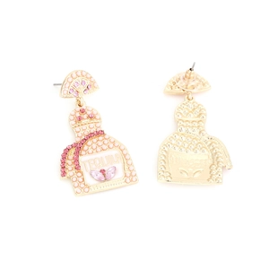 Detailed macro view of champagne bottle earrings with pink rhinestones and Tequila logo