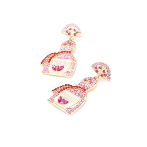 Detail of tequila bottle earrings with pink rhinestones and a green lime top