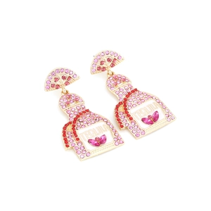 Detail of tequila bottle earrings with pink rhinestones and lemon slice accent