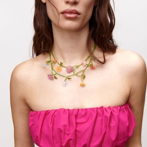 Macro detail of handmade floral beaded necklace with colorful frosted flower pendants