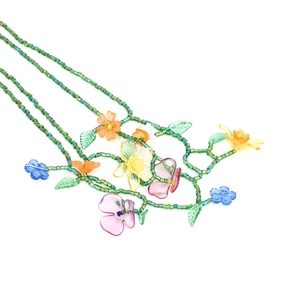 Detail of bohemian colorful flower beaded necklace with green seed beads and resin charms