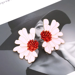 Detail shot of daisy earrings with pink enamel petals and gold plating on fashion background