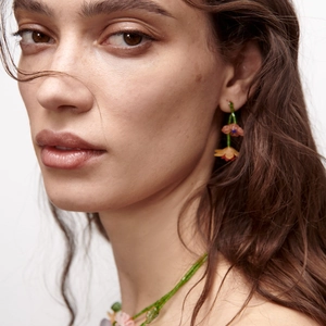 Handcrafted floral resin beaded earrings and necklace set worn by a model on plain background
