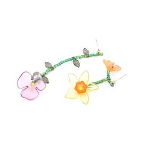 Detail of asymmetrical handmade beaded flower earrings with colorful resin petals
