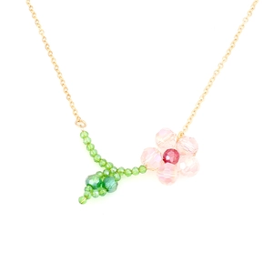 Pink crystal flower pendant necklace with green leaf detail and a slim gold-toned chain